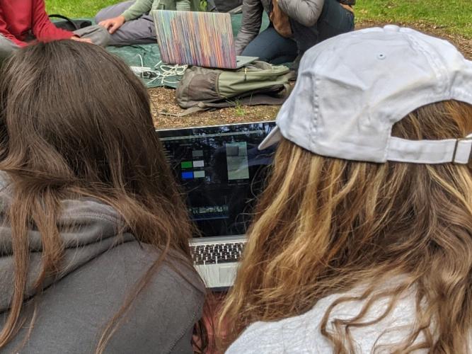 Photo of two people sharing a laptop to edit a video